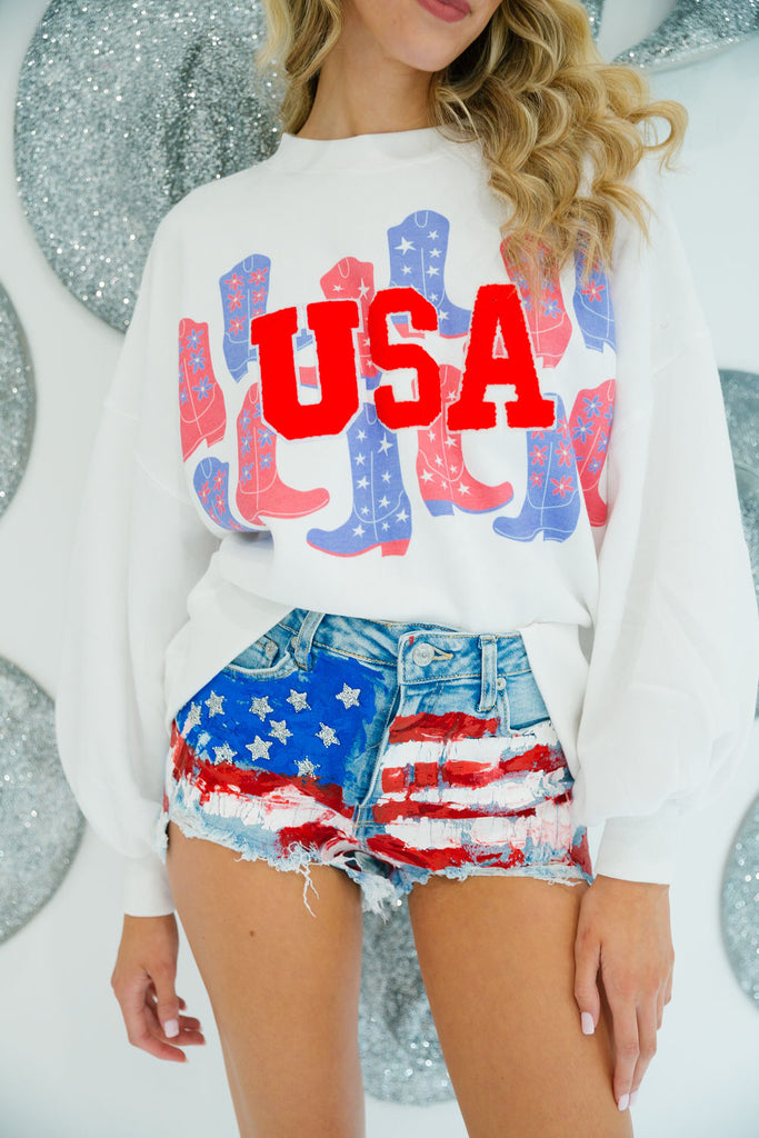 White cropped pullover with red and blue cowboy boots print and red "USA" letters