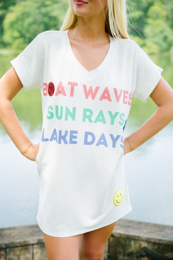 White t-shirt dress with "boat waves, sun rays, lake days printed, smiley patches, and a star patch. 