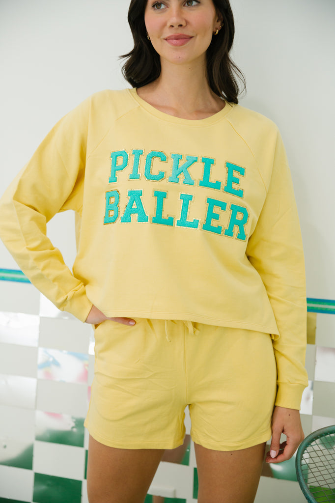 Yellow lounge set with "pickle baller" in teal terry letters. 