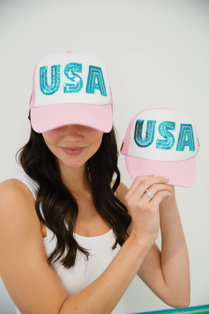 Kids pink and white trucker hat with blue sequin "USA" letters