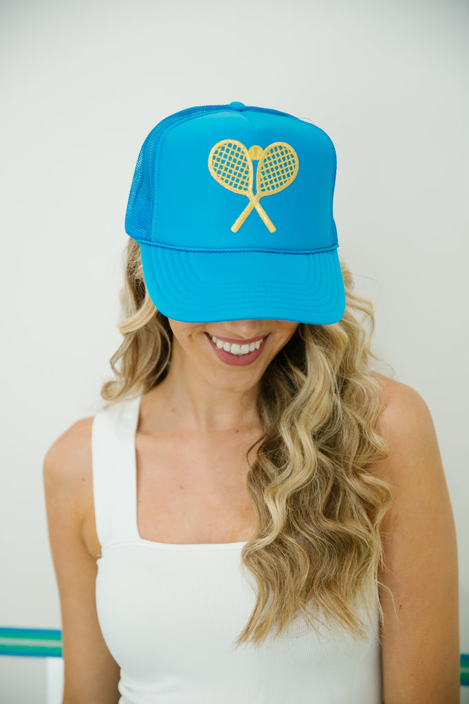 Blue trucker hat with gold tennis patch. 