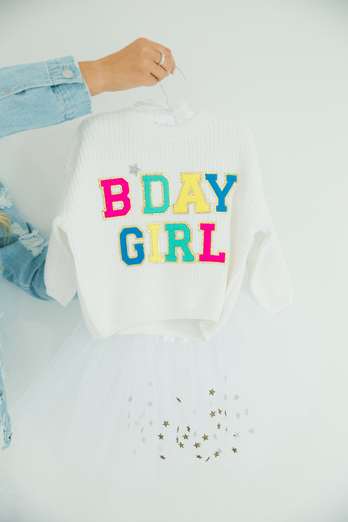 Kids white sweater with "bday girl" in colorful terry lettering. 