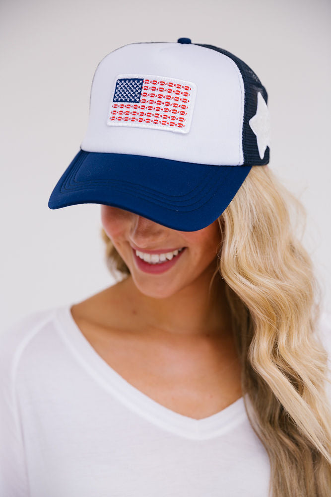 Navy and white trucker hat with American flag patch and white star patch on the side