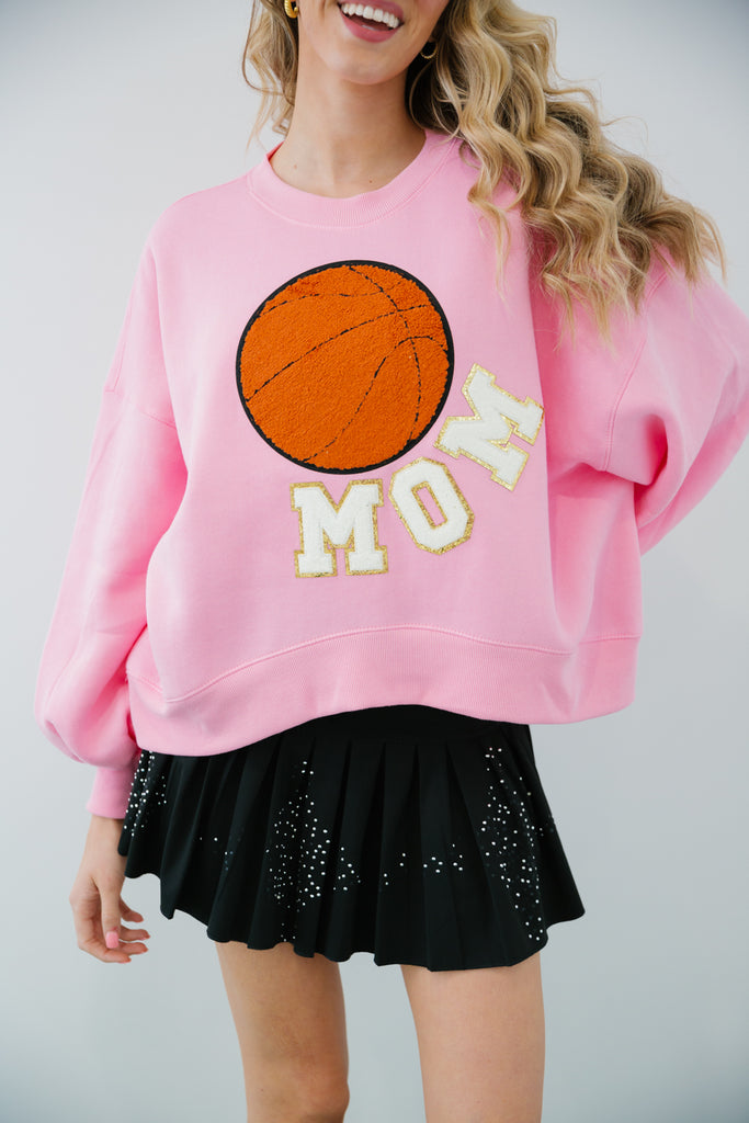Pink cropped pullover with Mom in white glam letters and a basketball patch