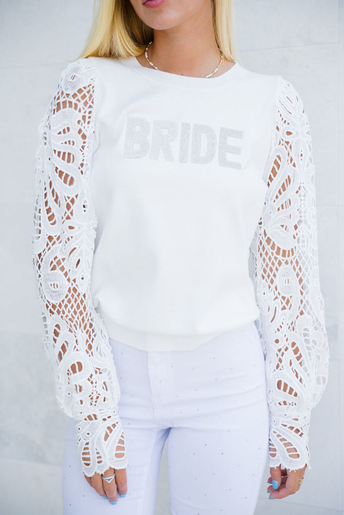 White top with long lace sleeves and "Bride" across the front. 
