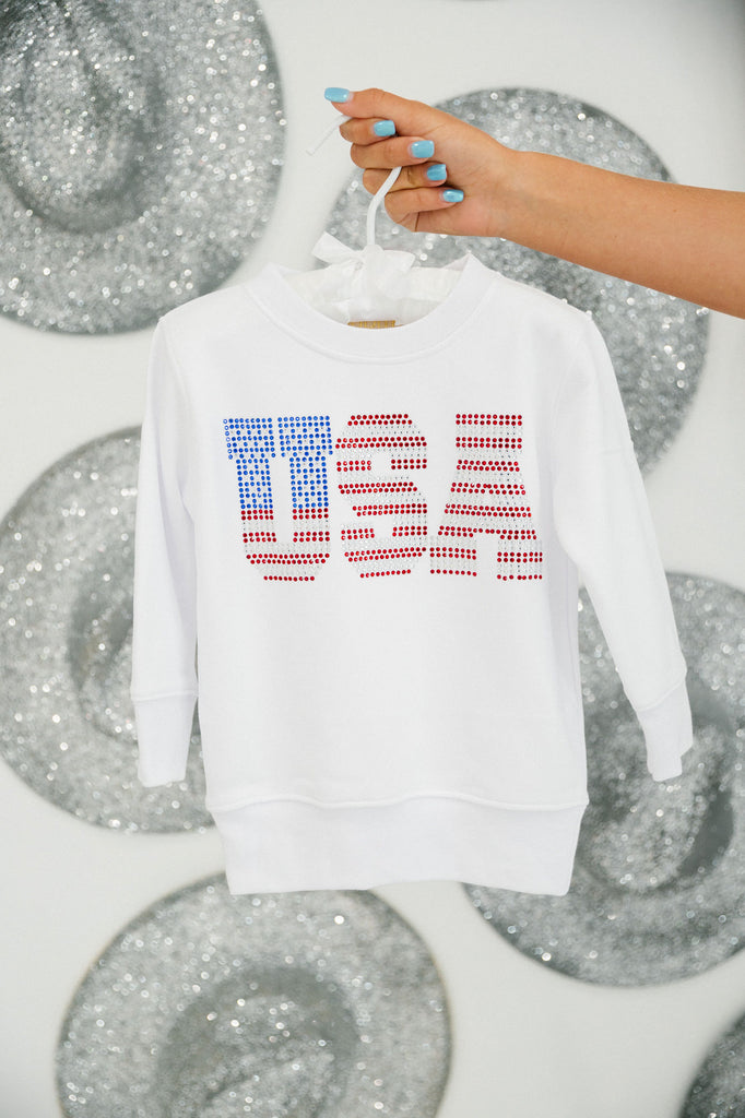 Kids white pullover with "USA" in red, white, and blue rhinestones. 