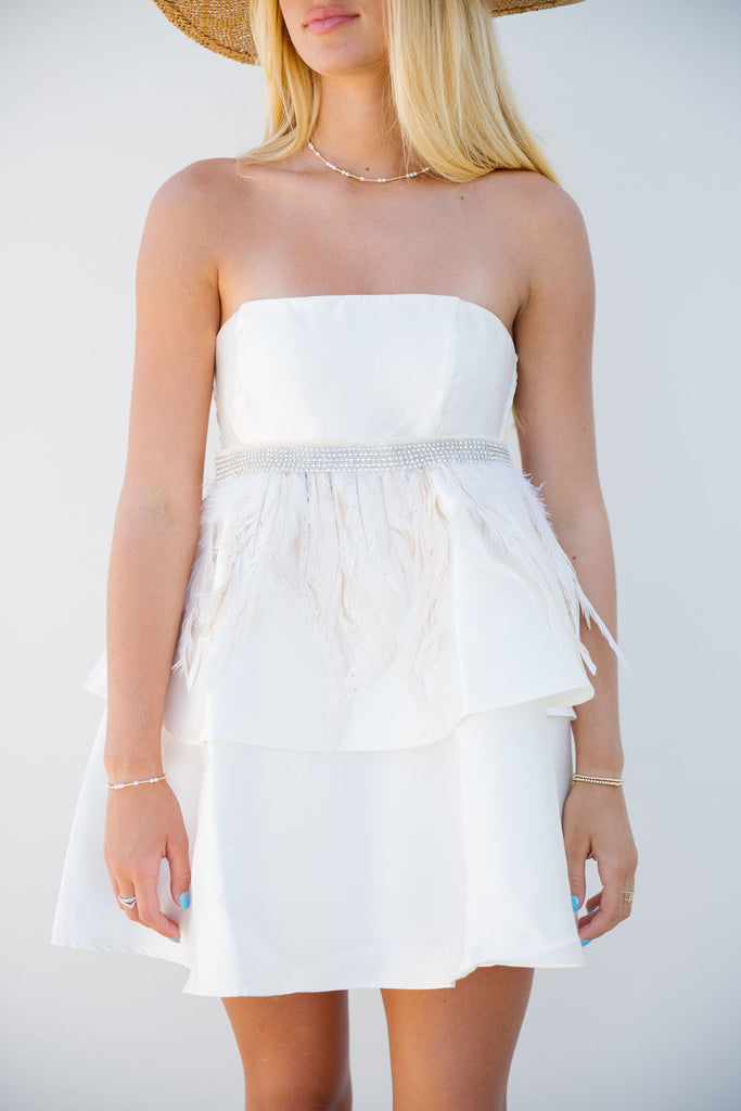 Ivory sleeveless dress with beaded waistband with feathers. 