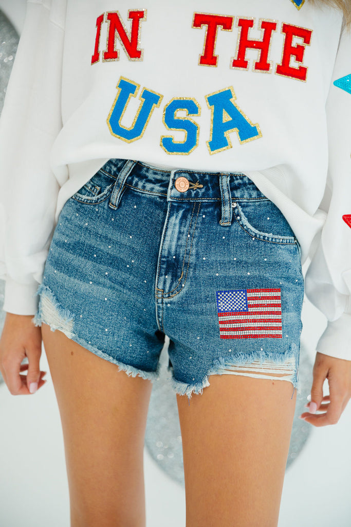 Denim distressed shorts with silver rhinestones and rhinestone American flag patch