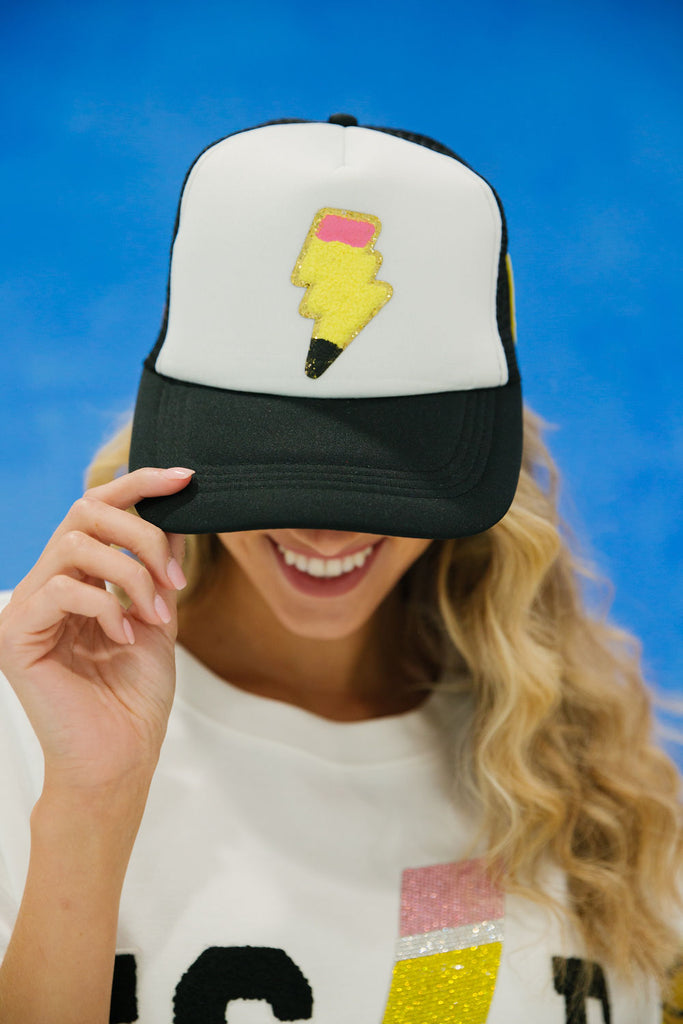 Black and white trucker hat with yellow, pink, and black lightning bolt