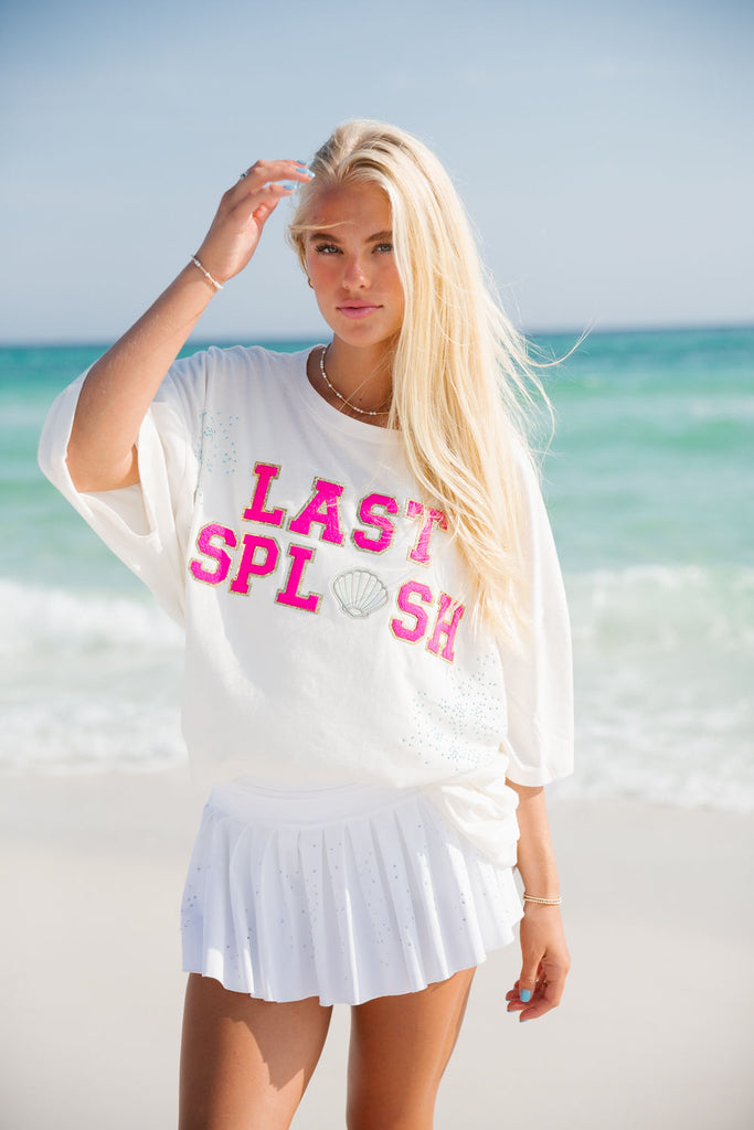 White tee with pink "White Splash" text across the front with blue rhinestones. 