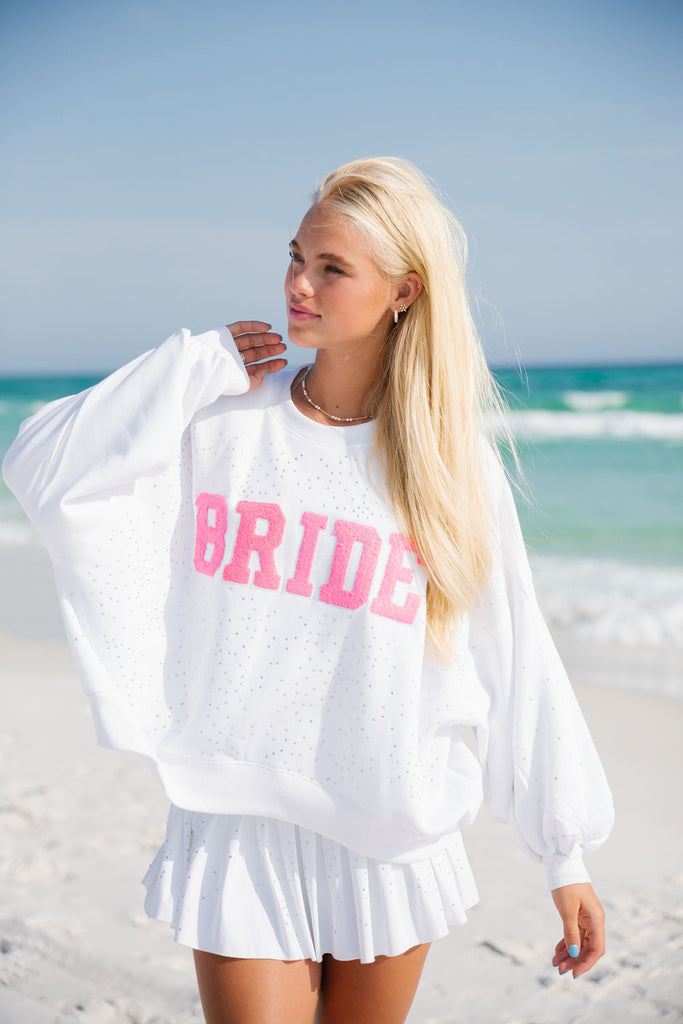 White pullover with pink "Bride" across the front with silver rhinestones. 