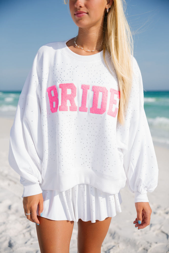 White pullover with pink "Bride" across the front with silver rhinestones. 