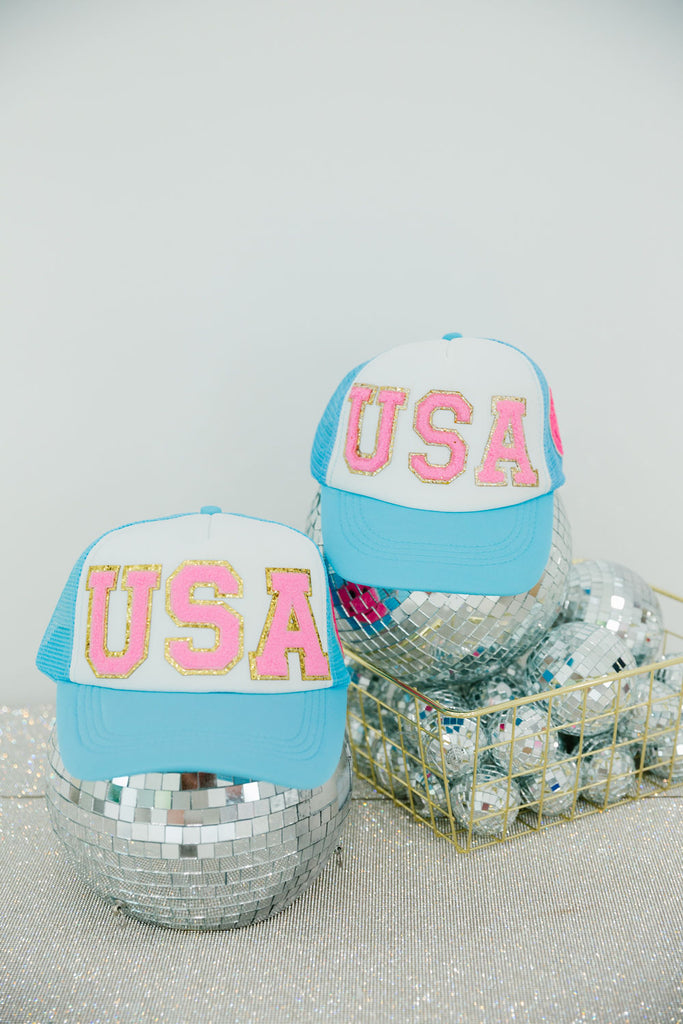 Blue and white trucker hat with pink "USA" letters