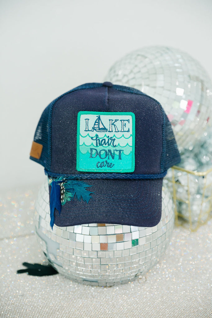 Navy baseball hat with Lake Hair Don't Care patch, feathers, and glitter option