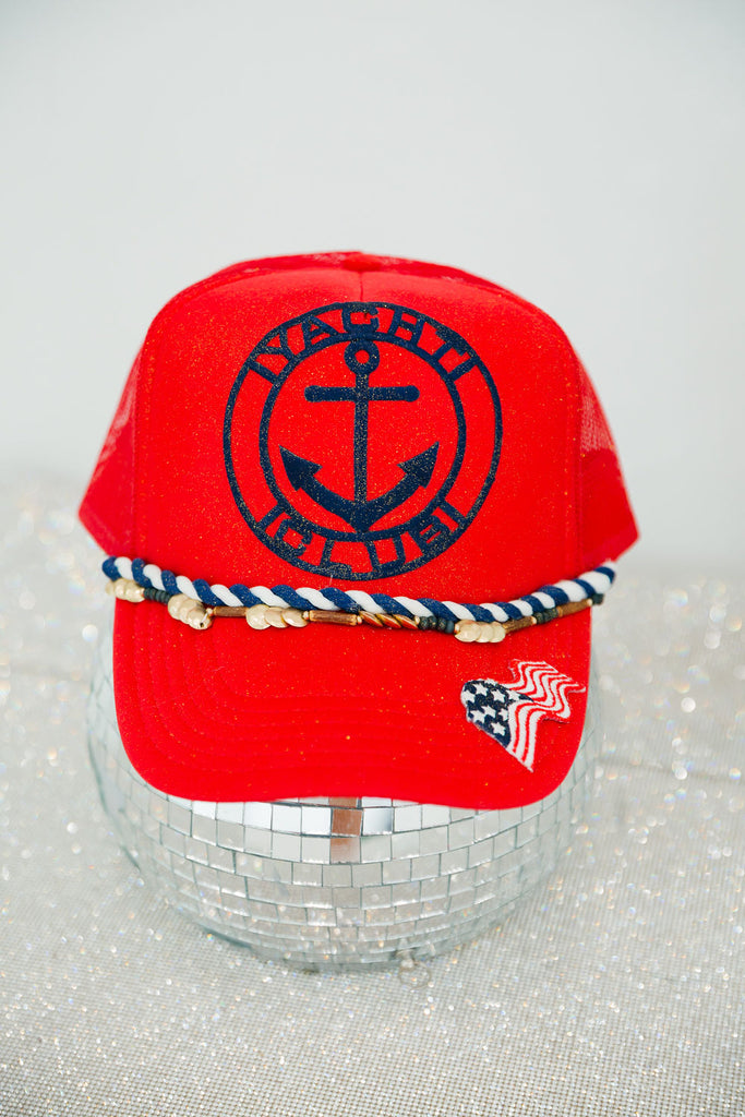 Red trucker hat with braided band, yacht club patch, and flag patch on the bill