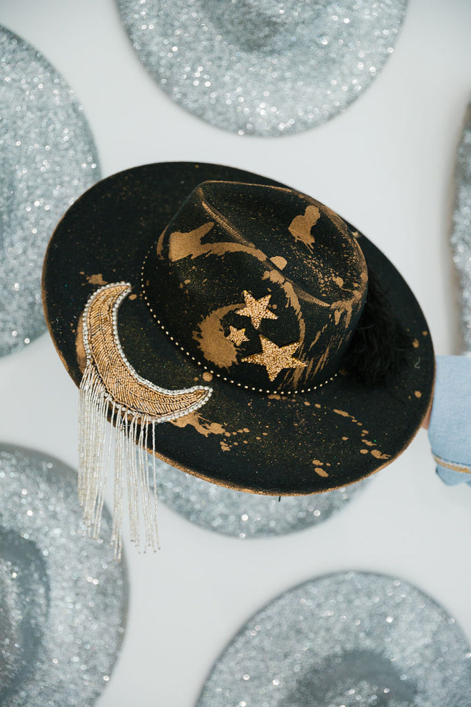 Black rancher with gold accents and a sequin moon patch with fringe