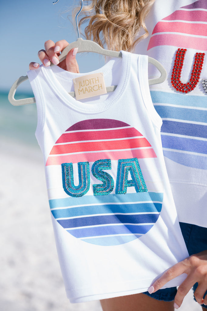 Kids white tank top with a colorful striped circle and blue sequin "USA" letters