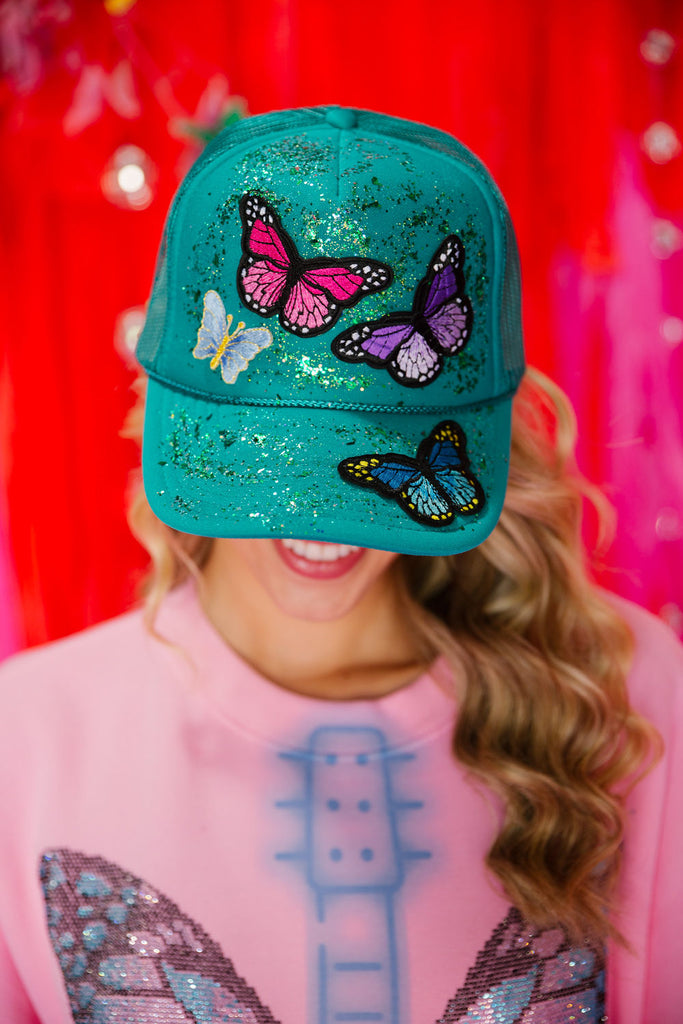Turquoise trucker hat with colorful butterfly patches and glitter
