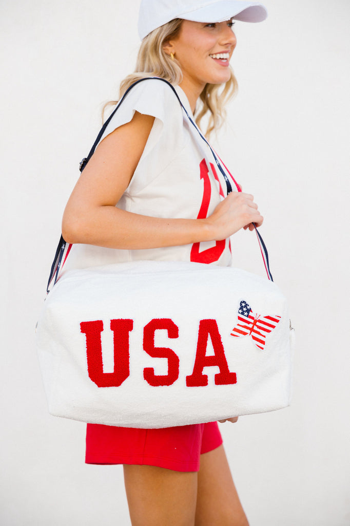 White large terry bag with red "USA" letters and an American flag butterfly patch