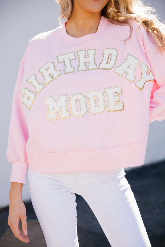 Pink cropped pullover with Birthday Mode in white glam letters