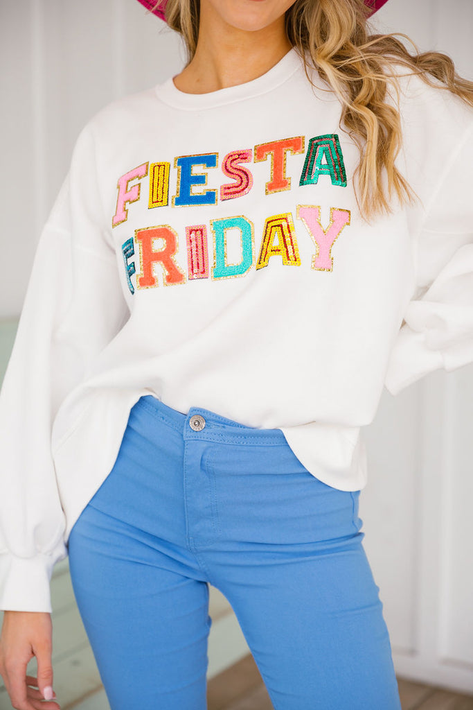 White cropped pullover with Fiesta Friday across the front in multi color and sequin letters