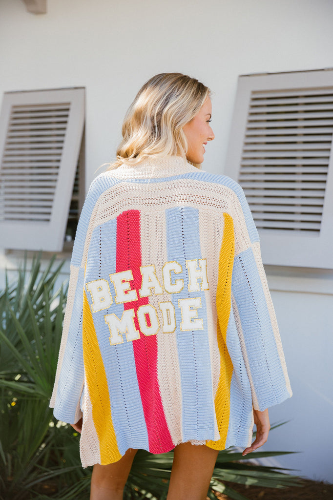 Colorful striped cardigan with Beach Mode in white glam letters across the back