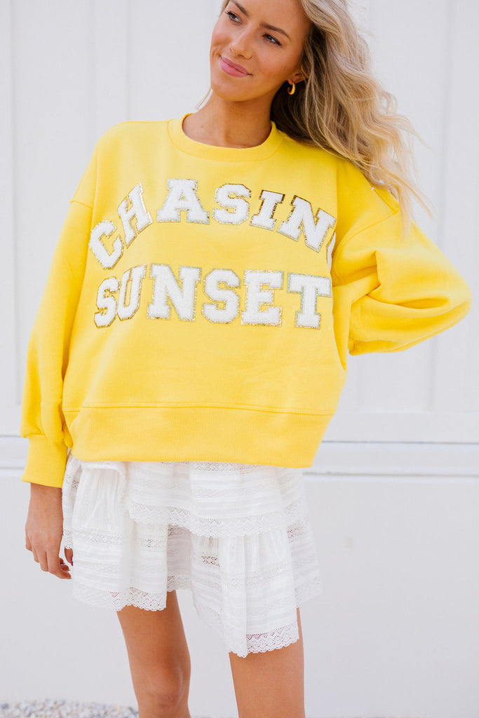 Yellow cropped pullover with Chasing Sunsets in white glam letters