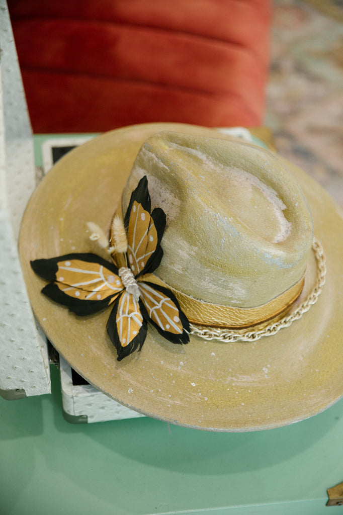 Gold rancher with black and gold feather butterfly