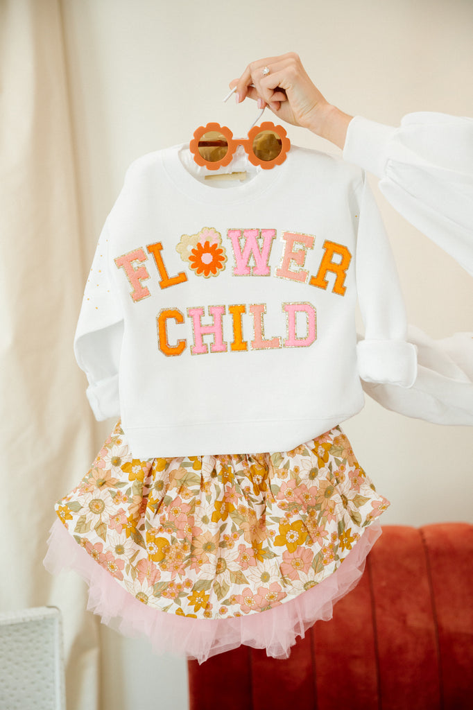 Kids white pullover with "flower child" in colorful mini terry lettering and a flower patch. 