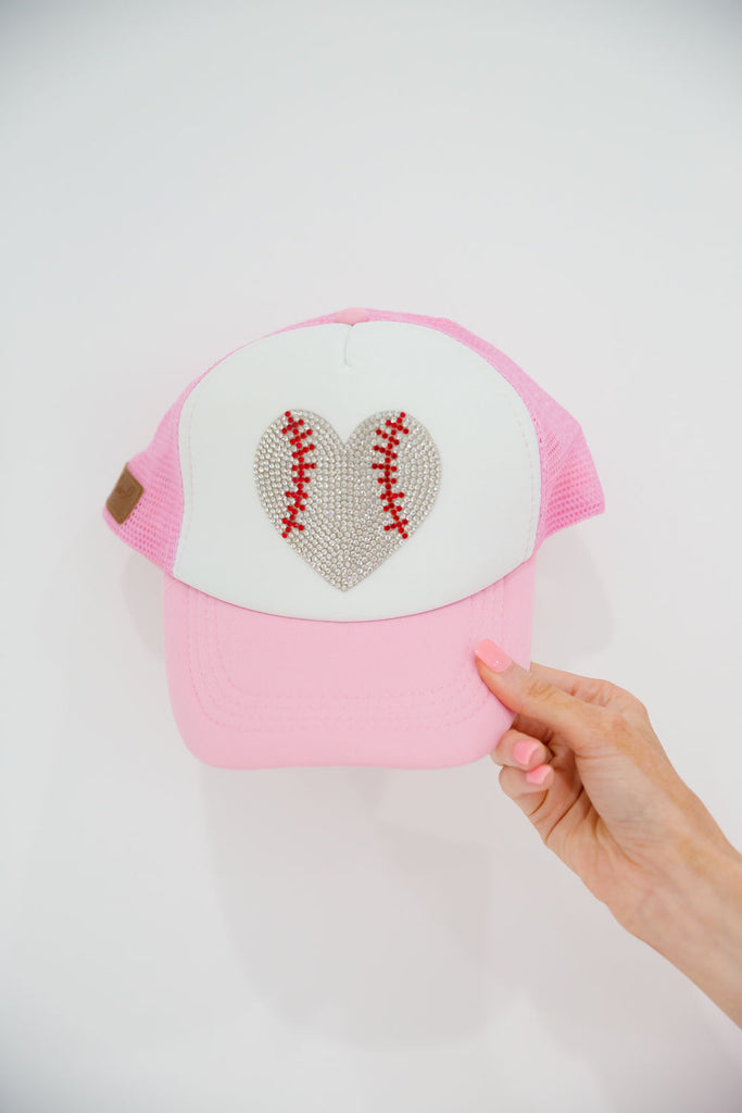 Pink and white trucker hat with a rhinestone baseball heart patch. 
