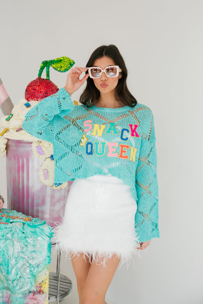 Blue sweater with Snack Queen in rainbow terry letters with a crown patch