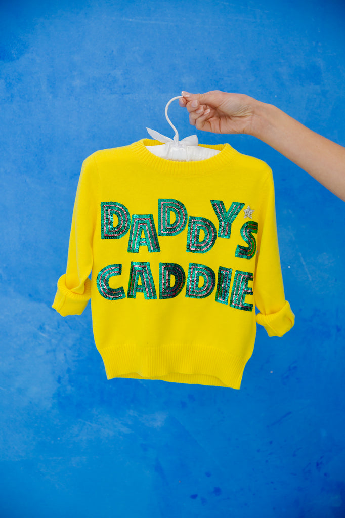 Yellow pullover with "daddy's caddie" in green sequin lettering and a silver rhinestone heart. 