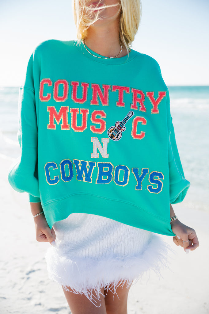 Mint cropped pullover with Country Music in coral terry letters and a guitar patch, a white glam N, and Cowboys in blue terry letters