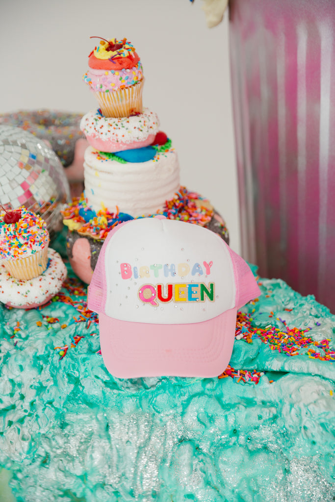 Pink and white trucker hat with "birthday queen" and rhinestone spray. 