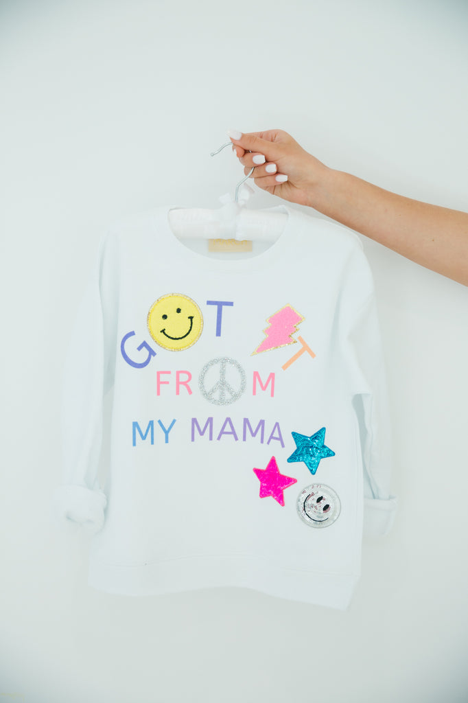 Kids white pullover with "got it from my mama" and smiley, star, peace sign, and lightening bolt patches. 