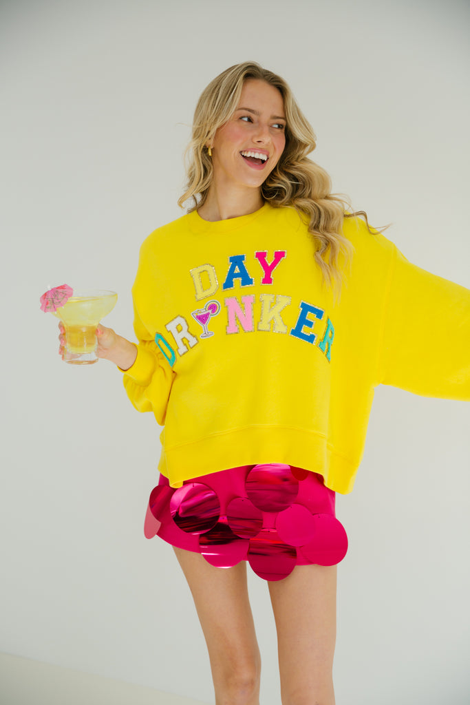 Yellow cropped pullover with colorful Day Drinker letters and martini patch