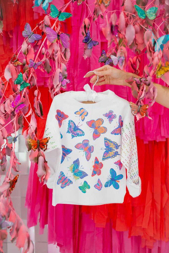 White pullover with multi colored butterflies and sequin spray 