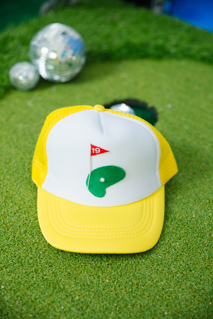 Yellow and white trucker hat with the 19th hole golf patch. 
