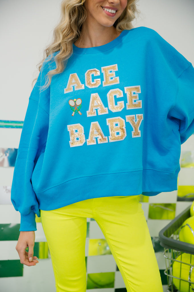 Blue cropped pullover with "Ace Ace Baby" with tennis patch. 