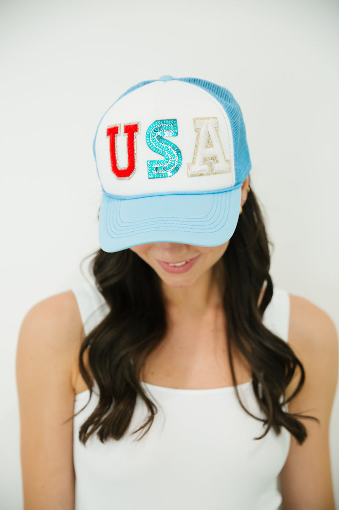 Blue and white trucker hat with red, white, and blue "USA" letters