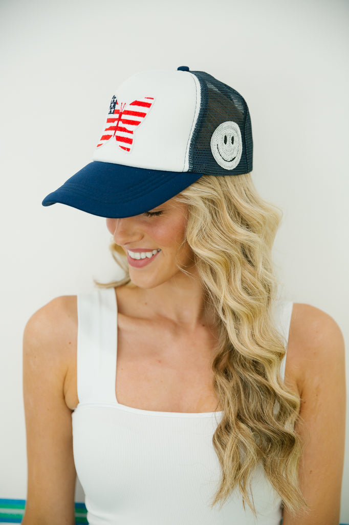 White and navy trucker hat with American flag butterfly patch