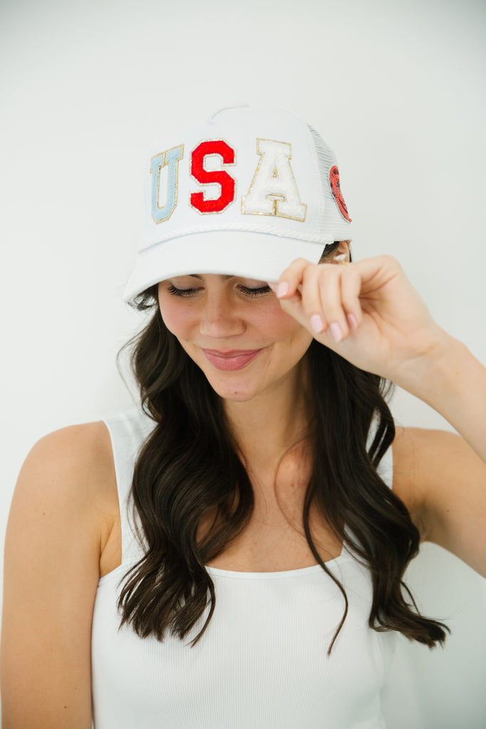 White structured hat with red, white, and blue "USA" letters with a red smiley face on the side