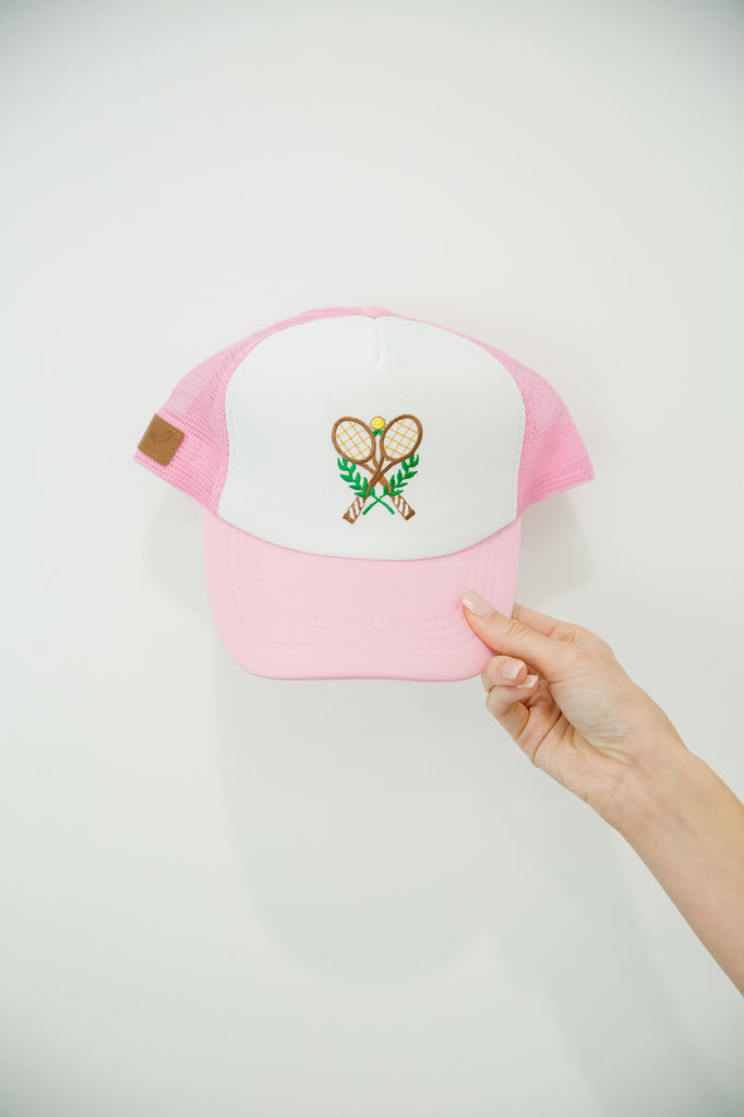 Pink and white trucker hat with tennis patch. 