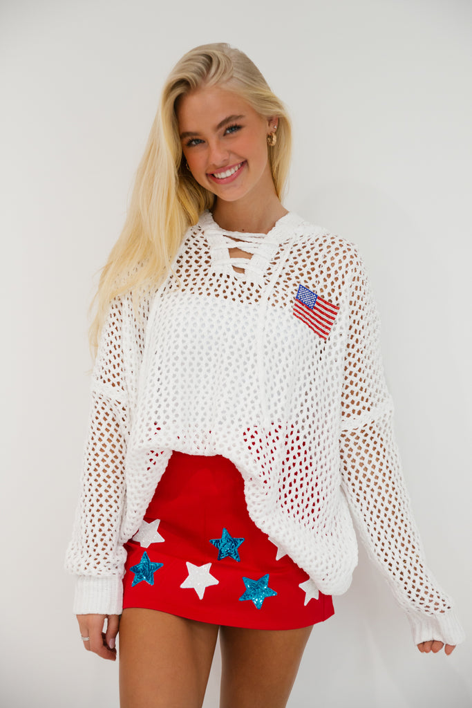 White crochet long-sleeve top with an American flag patch