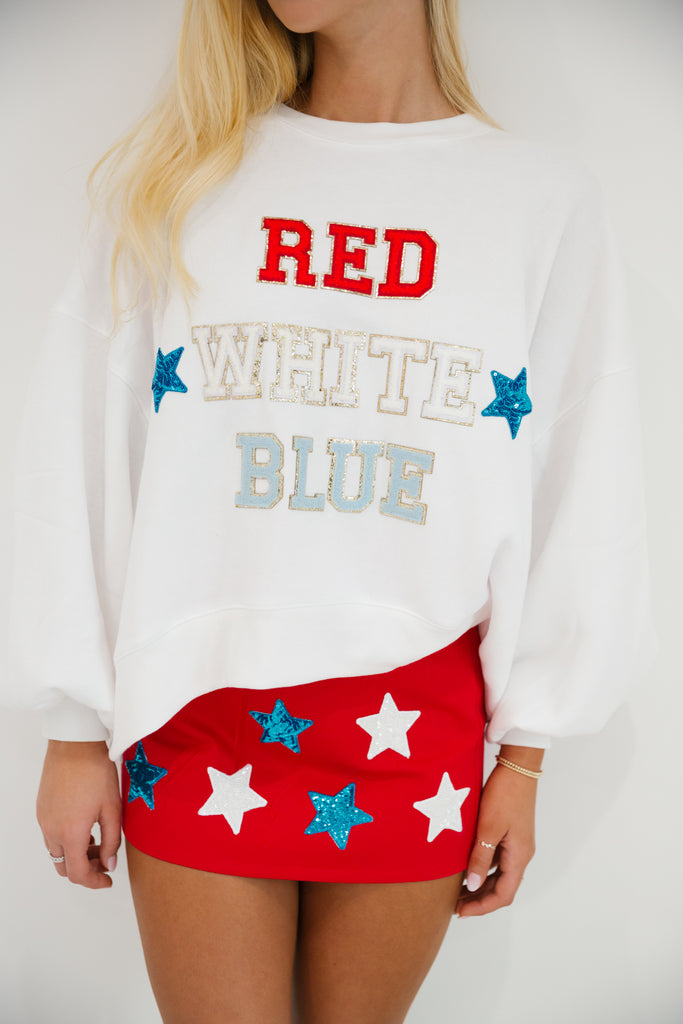 White cropped pullover with red, white, and blue letters with blue stars