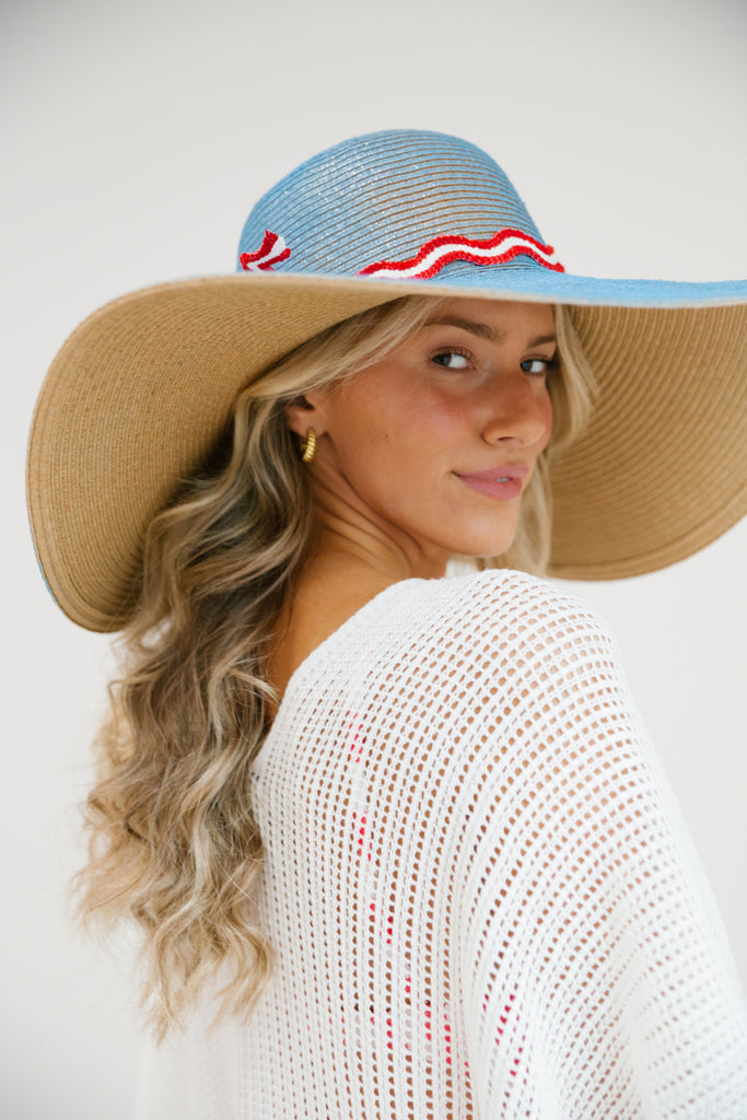 Blue floppy straw hat with red and white band