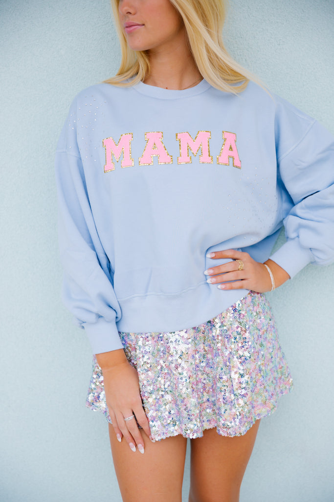 Light blue cropped pullover with "mama" in pink terry lettering. 