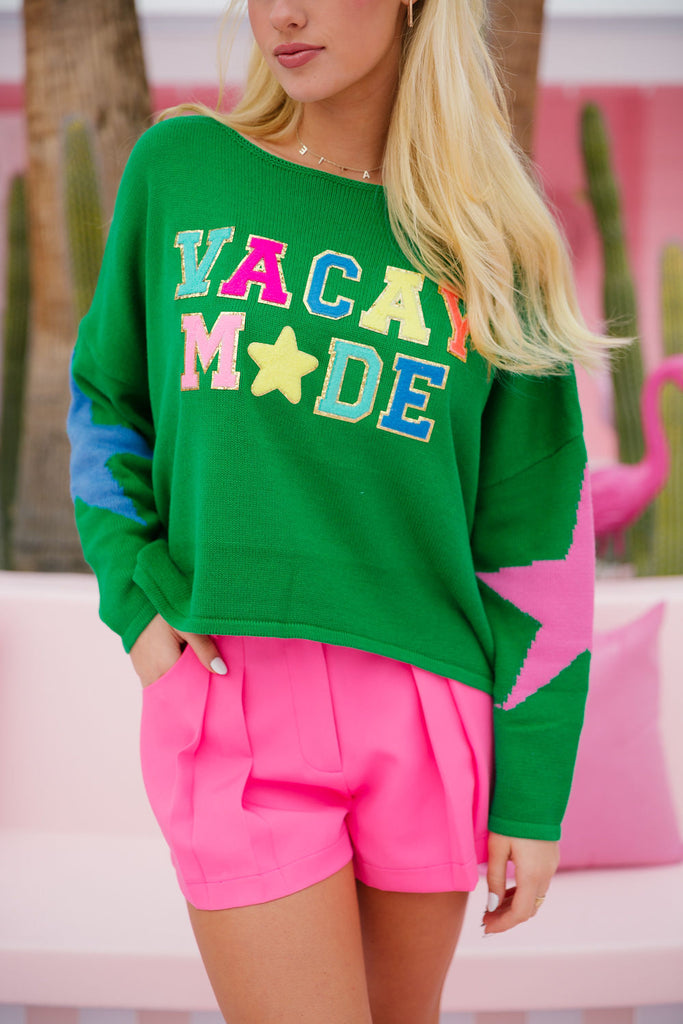 Green sweater with stars on the sleeves and Vacay Mode in rainbow terry letters with a terry star patch