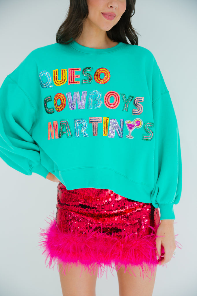 Teal cropped pullover with Queso Cowboys Martinis in sequin rainbow letters