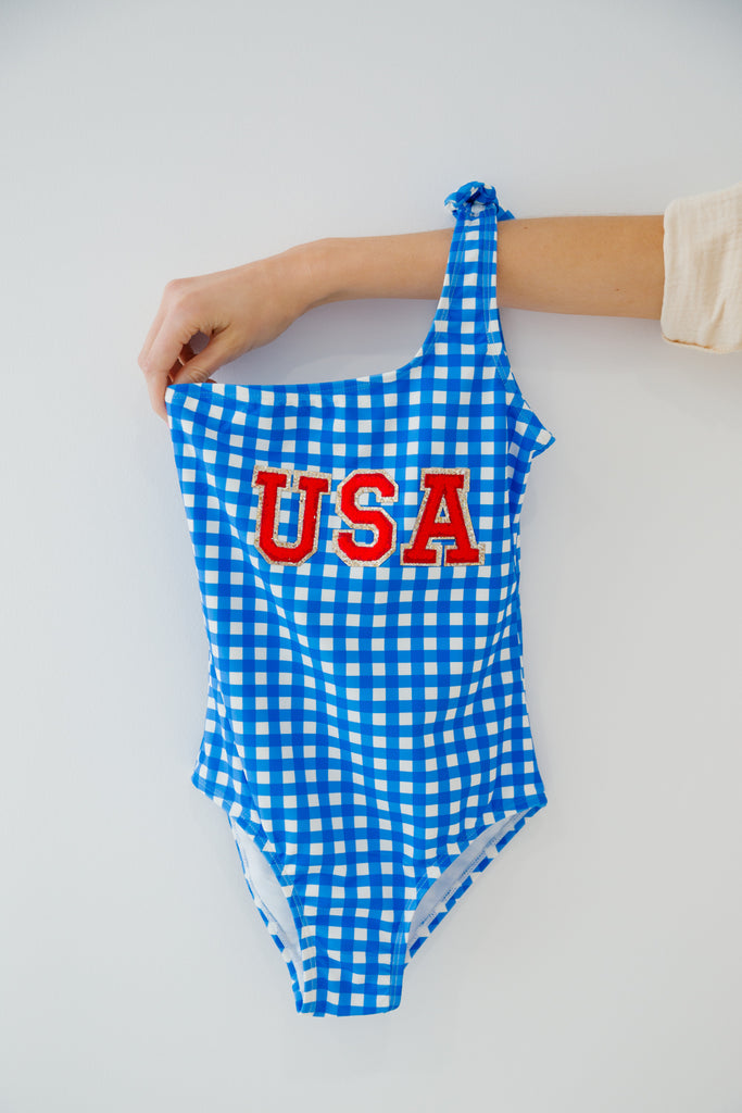 Kids one shoulder blue gingham one piece swimsuit with red "USA" letters